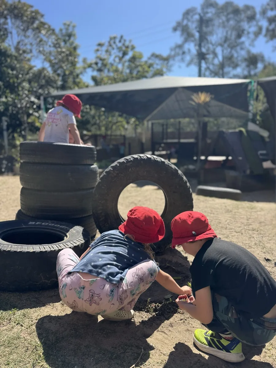 A child climbing over a stack of tyres